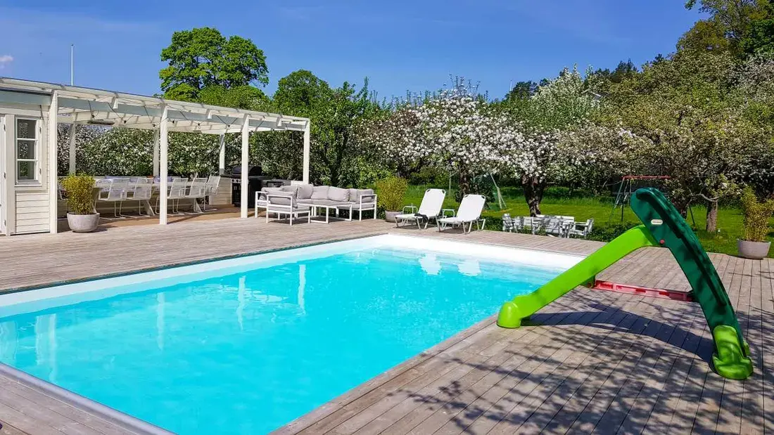 Pool med trädäck bland äppelträd