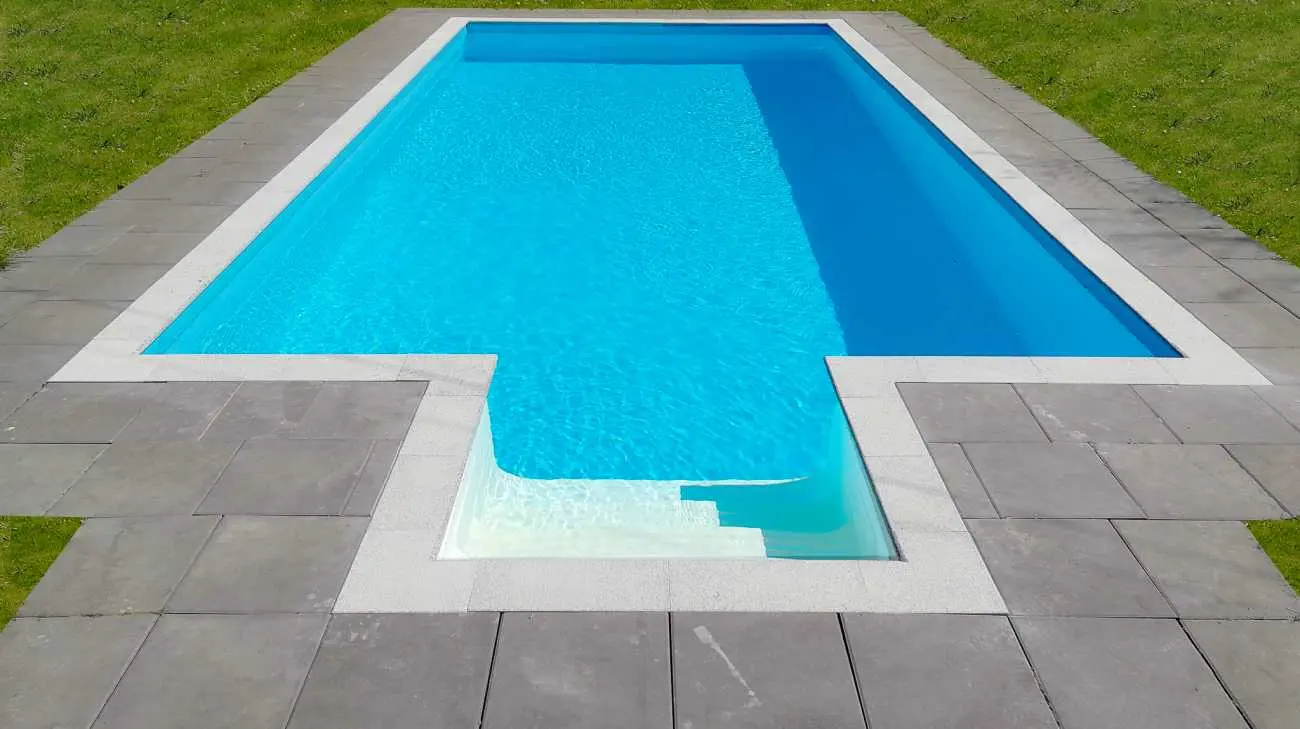 Pool med medelhavsblå liner och granitsarg