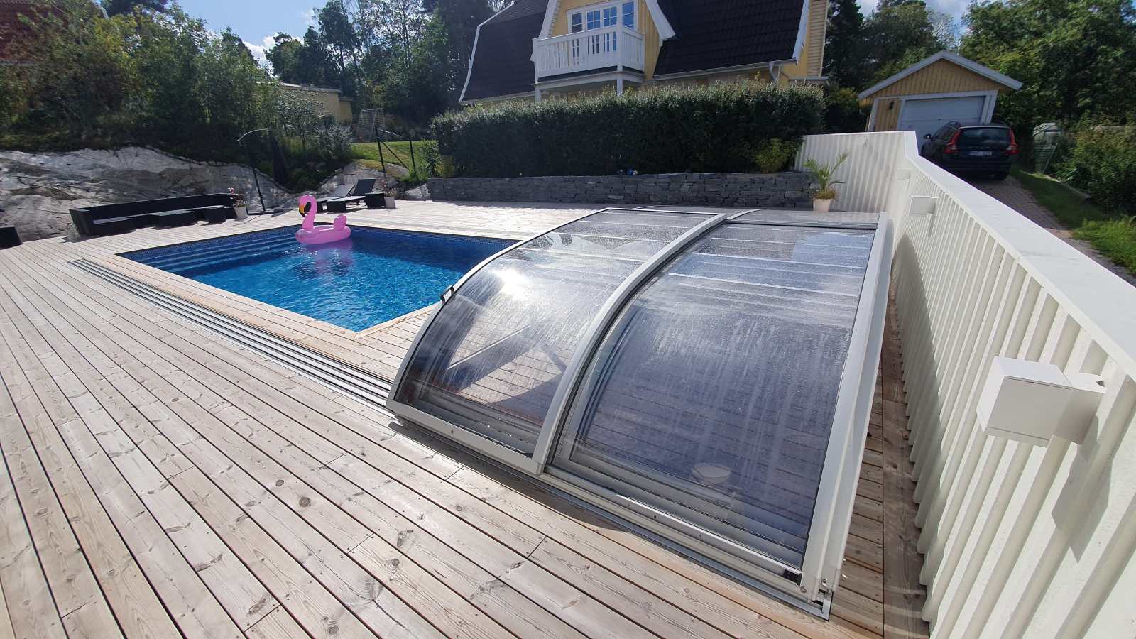 Pool med tillbakadraget pooltak på förlängda skenor