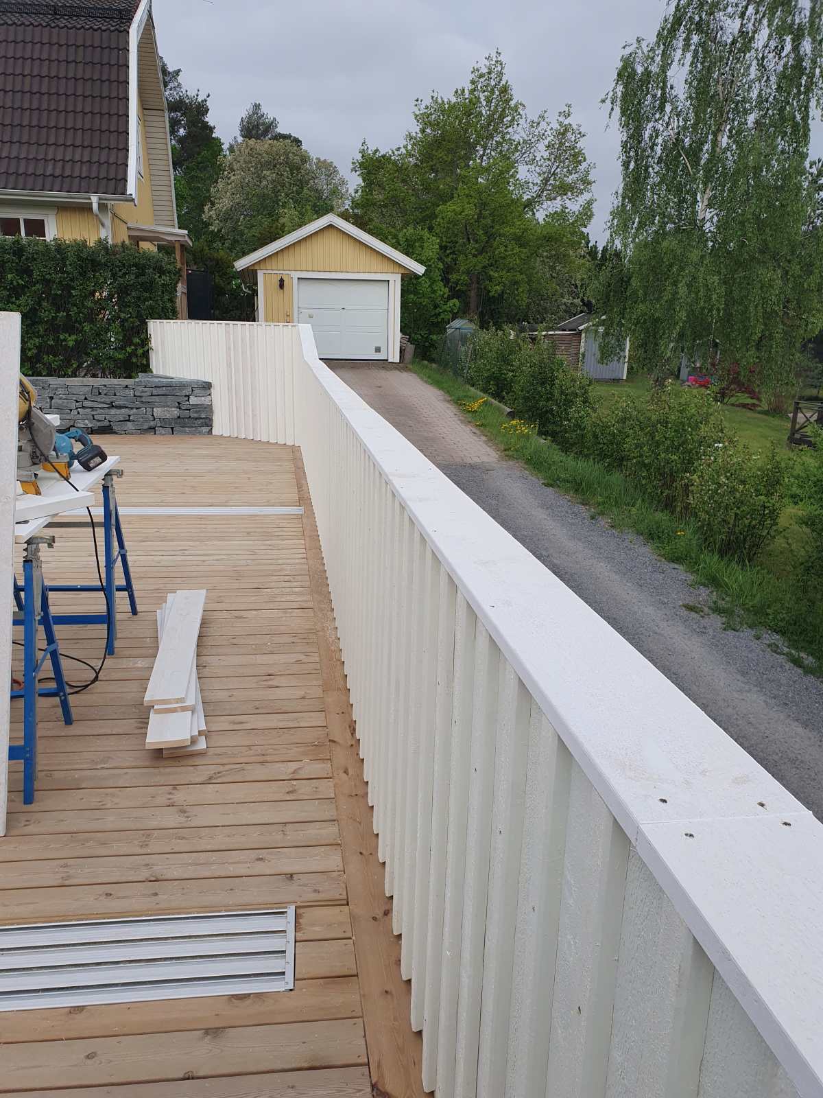 Vitmålat staket runt poolområdet i Huddinge