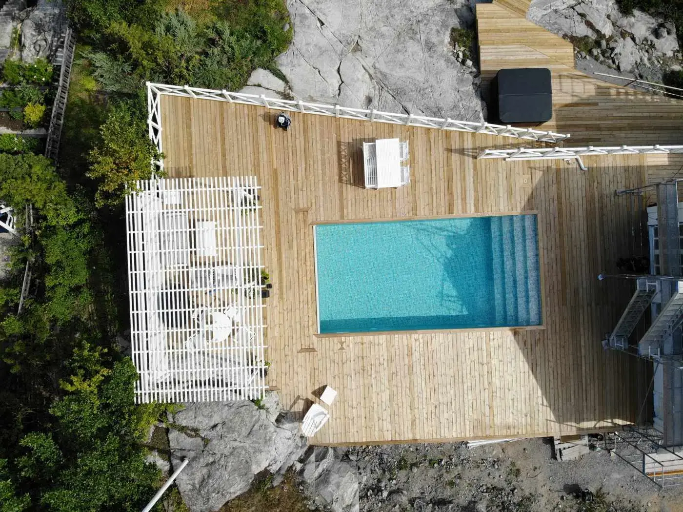 Poolen från ovan med trädäck och klippor