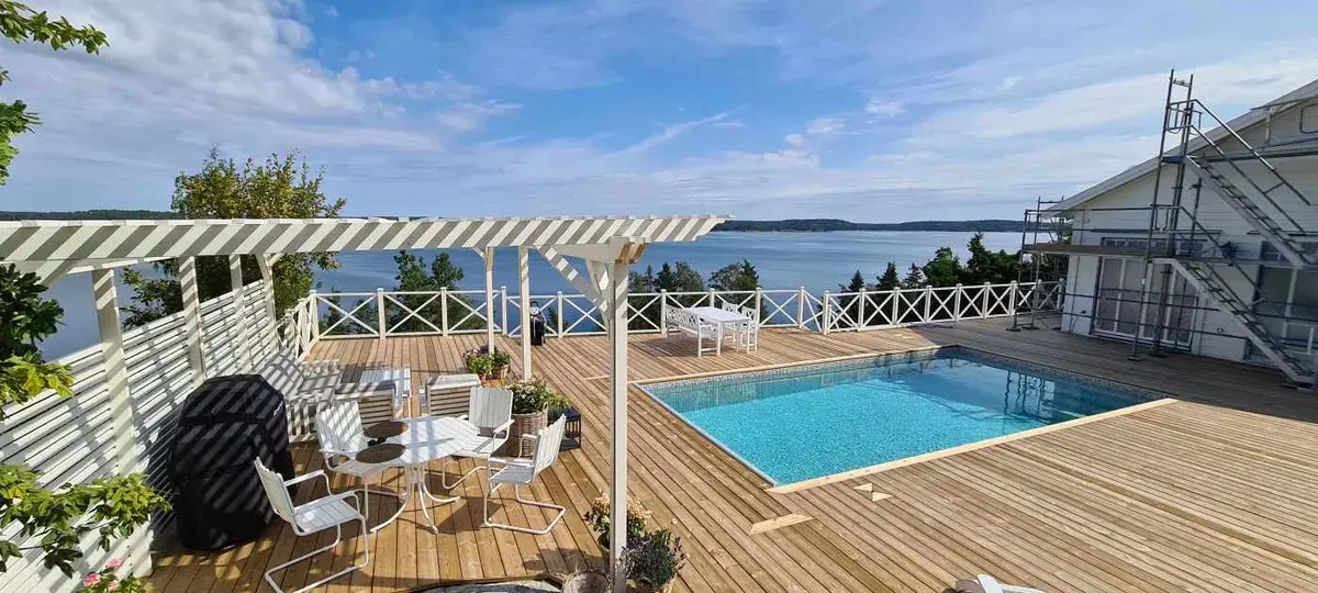 Loungedel under pergolan med havsutsikt