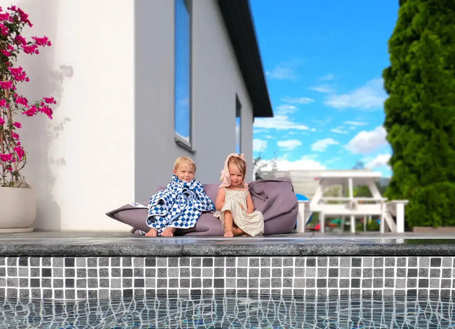 Familj som njuter vid sin nybyggda pool